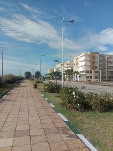 una acera con una luz de la calle a un lado de una carretera en BOUZNIKA Appartement au Centre ville, en Bouznika