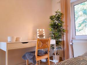 sypialnia z biurkiem i krzesłem obok okna w obiekcie Ferienwohnung SeeGräser Granitz w mieście Sellin