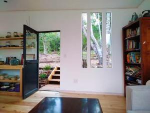 a living room with a door and a window at FireFly Starry Woods Cabin in Keurboomstrand