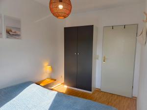 sypialnia z niebieskim łóżkiem i szafą w obiekcie Ferienwohnung SeeGräser Granitz w mieście Sellin +10 zdjęć