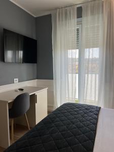 a bedroom with a bed and a desk and a window at Asso Residence Gold in Terni +13 photos