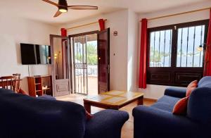 un salon avec un canapé bleu et une table dans l'établissement Villas with private pools - Just 7 min walk from beach, bars & dining, à Playa Blanca