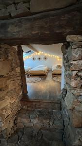 two beds in a room with a stone wall at La maison coup de cœur de Pont Caffino 9 couchages plus 2 sur demande in Maisdon-sur-Sèvre
