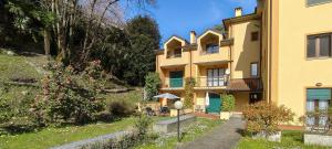a large yellow building with a garden in front of it at Verde Acqua in Stresa
