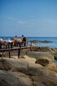 people sitting on a bench near a body of water at Sensi Paradise Beach Resort in Ko Tao