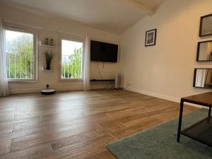 - un salon vide doté de parquet et d'une télévision à écran plat dans l'établissement Studio cosy indépendant et détaché dans une villa avec parking gratuit, à Marseille