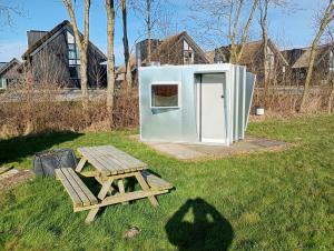 een picknicktafel en een koelkast in de tuin bij Tiny Houses in Heeg