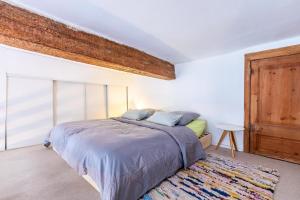 une chambre avec un lit et une grande fenêtre dans l'établissement Au Coeur de l'Ecusson - Appartement de caractère, à Montpellier