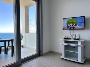 a mirror in a room with a television on a wall at Feli's Apartment in Castelsardo