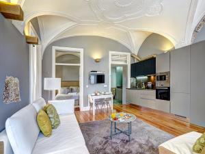 a living room with a white couch and a table at Sonel Investe Figueira Boutique Apartment by Get Your Stay in Lisbon