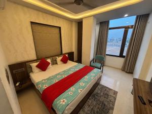a bedroom with a bed with red pillows and a window at Hotel The Royal Barbariq in Khātu
