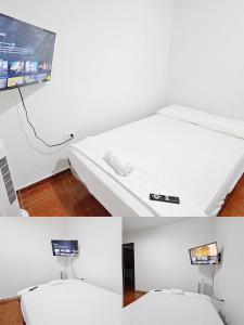 a white bed in a room with a tv at Mom's House Colombia Casa 2 in Cali
