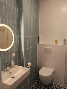 a bathroom with a white toilet and a sink at Blue Wave Stay - Free Parking in Scheveningen