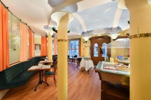 a restaurant with tables and chairs in a room at Altstadt Hotel Krone Luzern in Lucerne