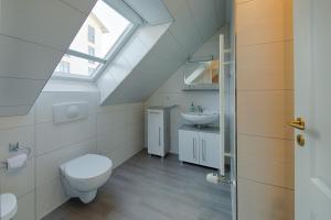 a bathroom with a toilet and a sink and a window at Panoramablick _ Heringsdorf in Heringsdorf +57 photos