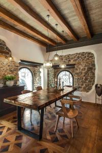 a dining room with a large wooden table and chairs at Robolo Boutique Hotel by H&T in Litochoro