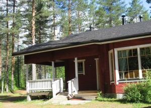 eine kleine Hütte mit einer Bank im Wald in der Unterkunft Cozy Cottage in Kerimaa in Savonlinna