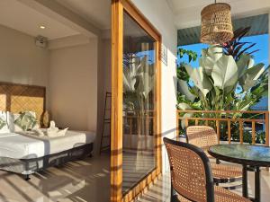 a room with a bed and a table and a balcony at Sing Siargao in General Luna