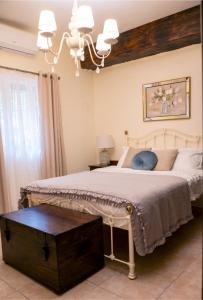 a bedroom with a large bed and a chandelier at Bingemma Paradise Farmhouse in Dwejra +23 photos