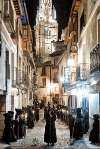 un grupo de personas caminando por una calle por la noche en Los Balcones de Maritxu, en Toledo