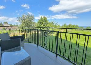 a balcony with a view of a field at Błękitna Przystań - pokoje z widokiem na Zatokę in Swarzewo