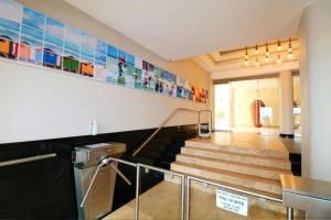 Una escalera en un edificio con un montón de cuadros en la pared. en The Waves Empire Apartment, en Muizenberg