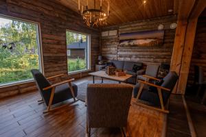 a living room with a table and chairs and windows at Wilderness Hotel Nellim & Igloos in Inari +121 photos