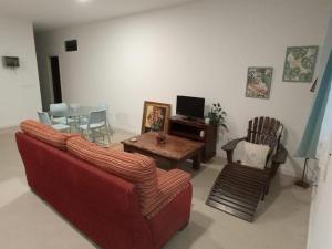 a living room with a red couch and a table at OLI VITA HOLIDAY HOME 4 O 2 PEOPLE Viveiro VUT-LU-3838 in Viveiro