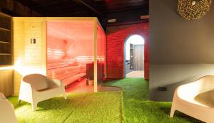 a living room with green carpet and a red brick wall at Belnoir by BRIGHT in Augsburg