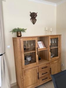 a wooden cabinet against a wall with a clock on the wall at Haus Rehkitz RE07 in Sögel