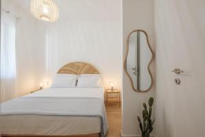 a white bedroom with a bed and a mirror at Villa Maison Rosabianca Country Escape - Costa Smeralda in Cugnana Verde