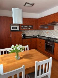 a kitchen with a wooden table with a vase of flowers on it at Ubytování v soukromí Anička in Lednice