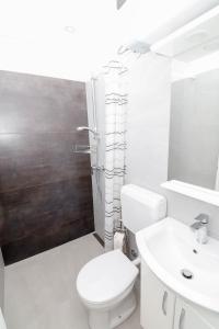 a white bathroom with a toilet and a sink at AMB Apartmaji in Spodnje Škofije +8 photos