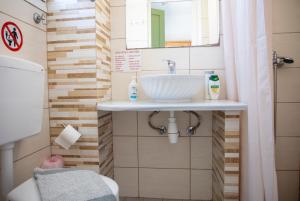 a bathroom with a sink and a mirror at Stefanie Studios in Egina