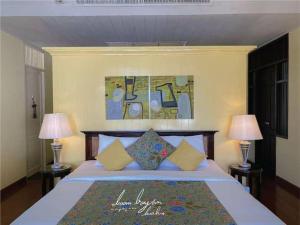a bedroom with a large bed with two lamps at Baan Bayan - Hua Hin - SHA Extra Plus in Hua Hin
