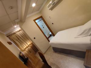 a bedroom with a bed and a table and a window at Hostal Moreno in Silla