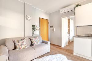 a living room with a couch and a clock on the wall at TheKeyStudio, Stella Marina Suite in Bordighera