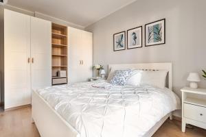 a white bedroom with a large bed and white cabinets at TheKeyStudio, Stella Marina Suite in Bordighera