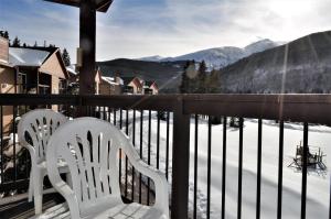 two chairs on a balcony with a view of a snowy mountain at Blue River Condos 3 Bed 2 Bath BRLR in Blue River