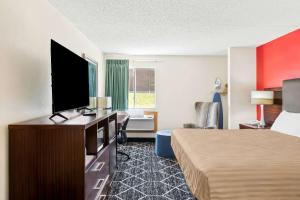 ein Hotelzimmer mit einem Bett und einem Flachbildfernseher in der Unterkunft Econo Lodge Emporia in Emporia