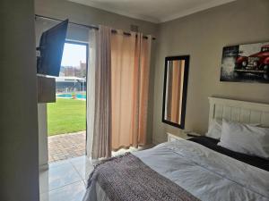 a bedroom with a bed and a large window at 41 Fourth Road Guest House in Johannesburg