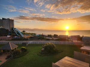 a sunset over the ocean and a park with a playground at Beautiful Sea view apartment 45 De Valle Diaz Mosselbay in Mossel Bay