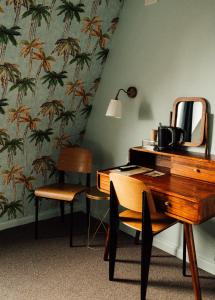 a desk with a mirror and a chair in a room at Hôtel Azur in Reims