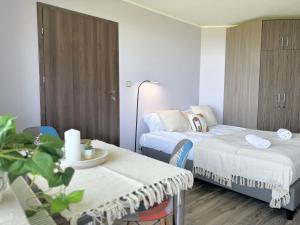 a hospital room with two beds and a table at Błękitna Przystań - pokoje z widokiem na Zatokę in Swarzewo