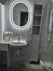 ein Badezimmer mit Waschbecken, Spiegel und Dusche in der Unterkunft Apartamenty Stynka Apartament Pod Gwiazdami in Misdroy + 21 Fotos