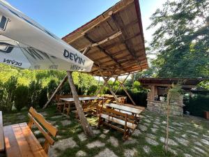 Un patio con una sombrilla y una mesa y sillas. en Вилно селище Зора, en Shkorpilovtsi