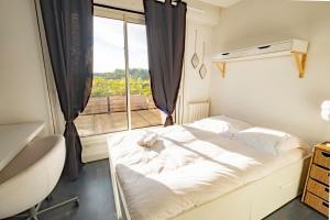 une petite chambre avec un lit et une fenêtre dans l'établissement Le Bloy - Grande terrasse, Proche Paris, à Fontenay-aux-Roses