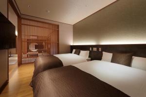 Rúm í herbergi á Marukyu Ryokan