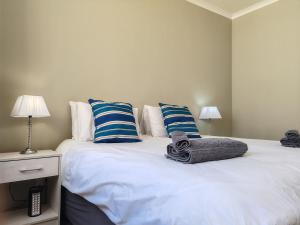 a bedroom with two beds with blue and white pillows at Sunrise Deck Empire Apartment in Muizenberg