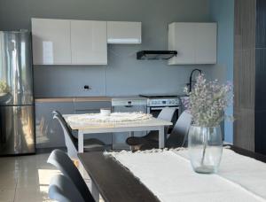 a kitchen with a table and a vase of flowers at Błękitna Przystań - pokoje z widokiem na Zatokę in Swarzewo
